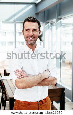 Young smiling professional with folded arms looking at camera