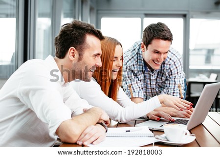 Three web designers looking at a laptop screen