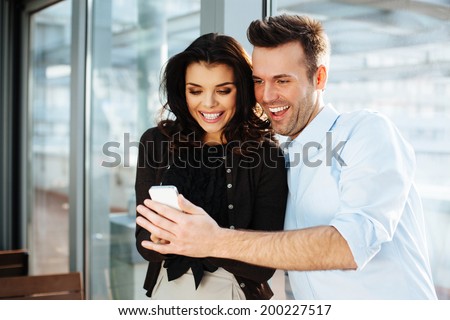 Young couple of professionals browsing massages on the phone