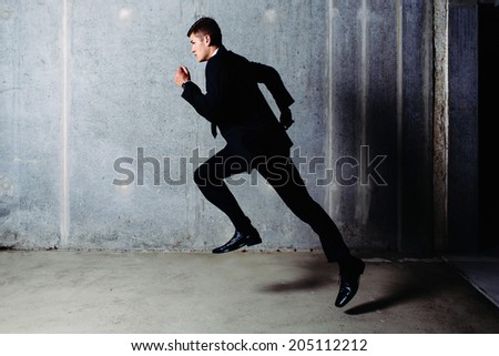 Photo of a young  running professional in a suit
