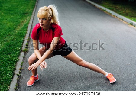 Young attractive woman warming up before her morning jog