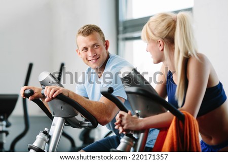 Couple training indoor cycling in a gym