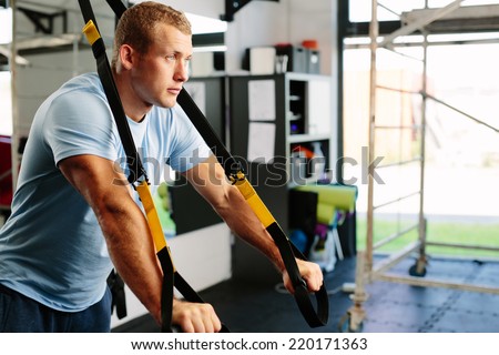 Photo of a muscular man doing a suspension training