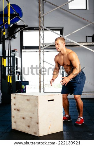 Photo of a muscular man doing a box jump