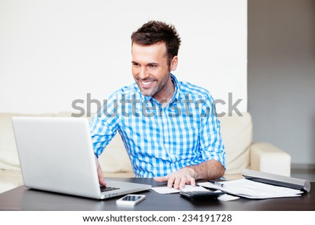 Handsome young man paying online using a laptop
