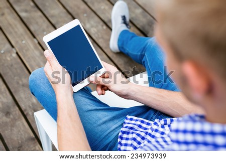 Relaxed man reading on tablet