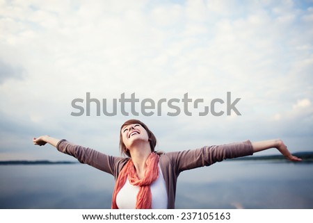 Freedom. Happy young woman with arms raised, outdor.