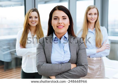 Three female business partners posing in an office