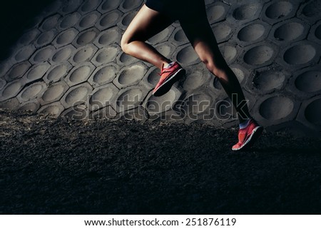 Strong Young woman running, sprinting at night in urban scene