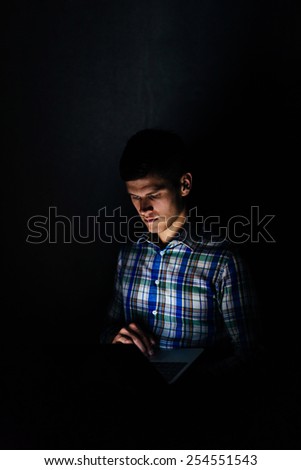 Dark portrait of IT specialist hacking with laptop