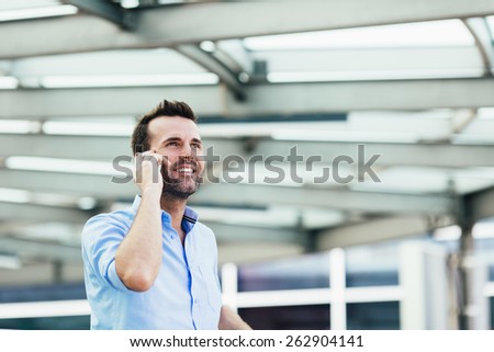 Young businessman talking on phone outside the office