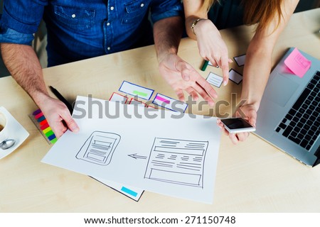 Two web designers brainstorming for ideas and sketching