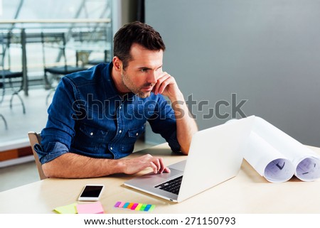 Architect at work checking construction calculations on his laptop computer
