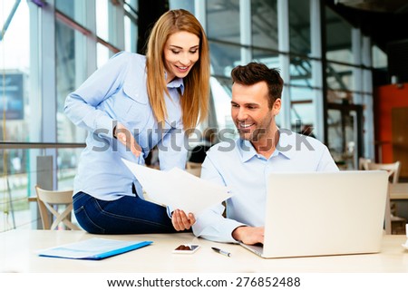 Successful managers smiling at sales figures in an office