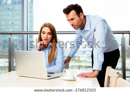 Two managers concentrating on an online problem in an office