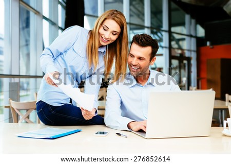 Two managers discussing a document at meeting in an office