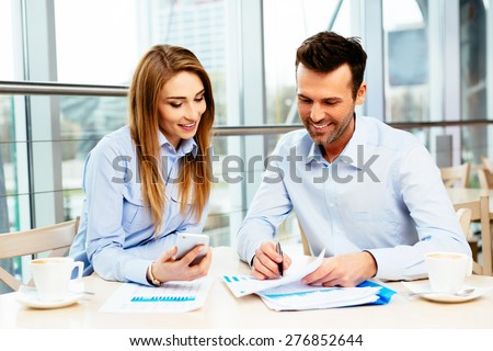Two managers in a business meeting analyzing data