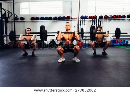 Portrait of three man at gym training clean and jerk