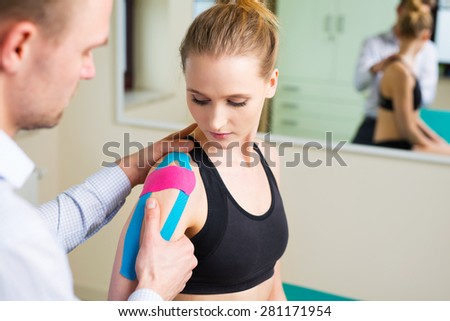 Woman having shoulder physical therapy with kinesiotaping