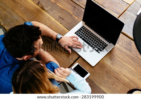 two people using laptop computer at cafe - mockup
