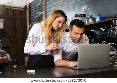Two restaurant owners working with laptop