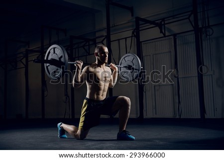Young athlere training lunges with barbells