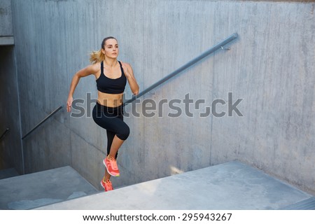 Athletic woman running up stairs during cardio - interval training