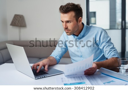 Sad man paying bills on his laptop