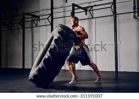 Athlete flipping tire at gym