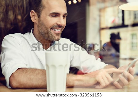 Handsome man in coffee shop using his smartphone