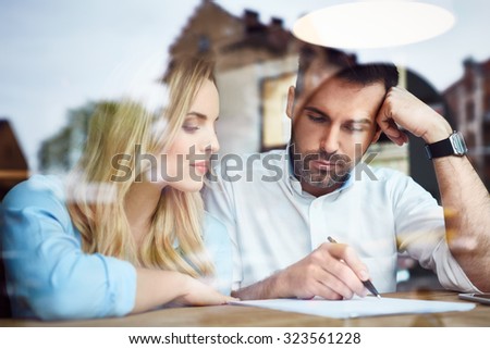 Couple at cafe reading bank contract document