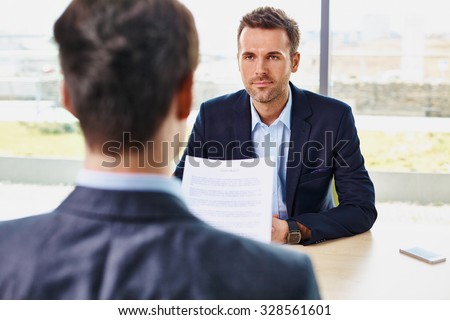 Job interview - candidate reading contract document, offer