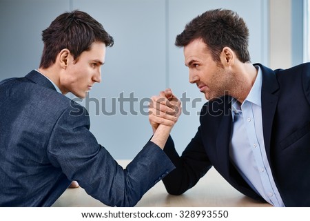 Business competition - two businessman arm wrestling