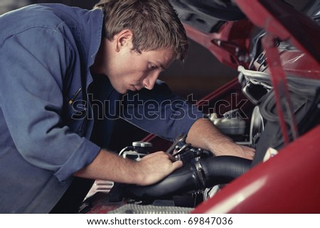 Mechanic at work fixing car in auto service