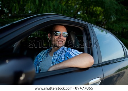 Handsome man smiling in his own car