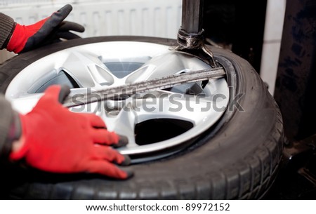 Mechanic changing tire in car service. Tire rotation machine