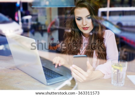 Young female blogger writing article at coffee shop