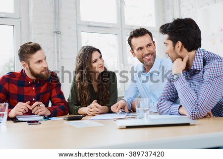 Casual business partners talking during business meeting in office.