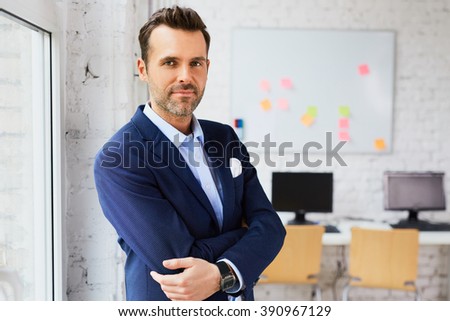 Handsome business man at office looking at camera