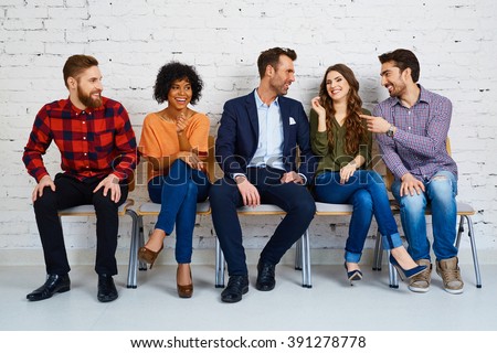 Group of happy young people waiting for exam at university