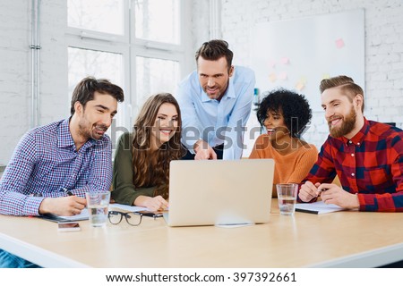 Creative agency coworkers discussing new project on laptop
