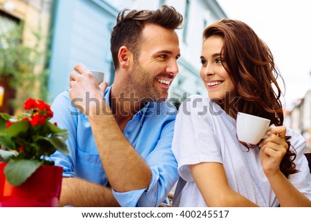 Happy couple drinking coffee in outdoors cafe on summer vacation