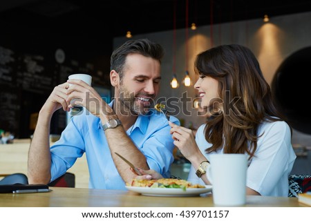 Happy couple at restaurant eating lunch, having fun