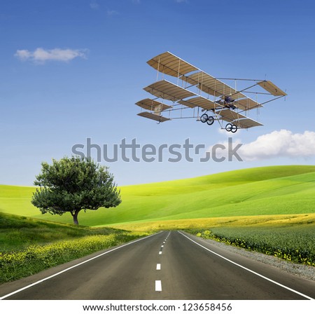 Green Grass Field Landscape with fantastic clouds in the background and old aircraft on the green field and road