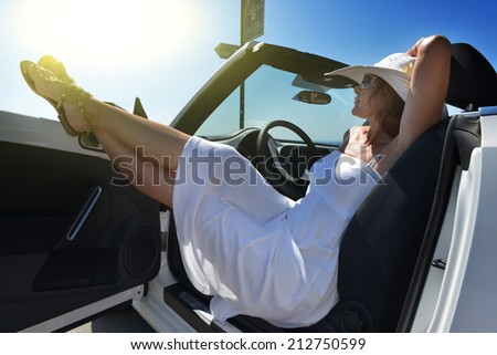 Women\'s legs sticking out the car window . The concept of relaxation and travel