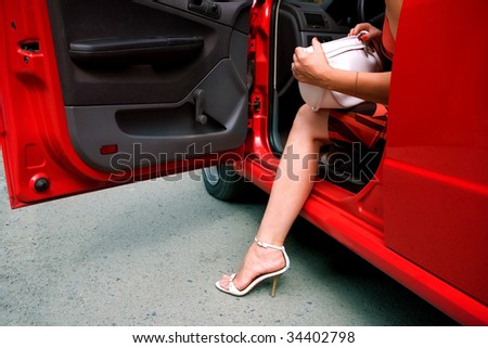 The woman leaves the red car