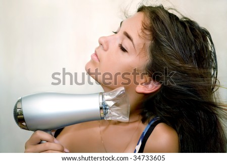 The girl dries hair the hair dryer
