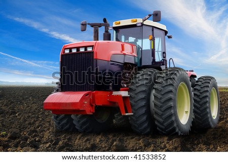 Wheel tractor on an arable land in the field.