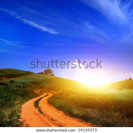 dirt road in grass and sunset