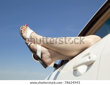 Woman legs out the windows in car above the clouds.